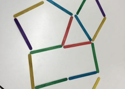 Popsicle sticks arranged to show different enclosures with common edges